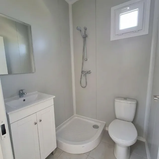 The bathroom of a 6 × 3 m container: shower tray, basin with cabinet and toilet