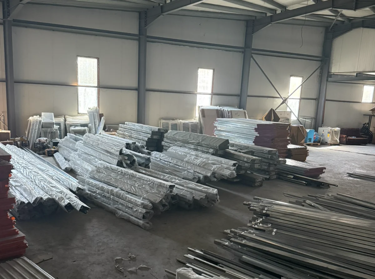 The production hall of our factory in China: steel profiles and panels stacked on the floor